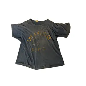 Vintage t shirt med tryck, som ni ser är den väldigt urtvättad men annars i bra skick från champion 
