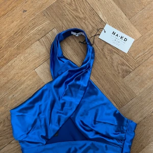 Festtopp Nakd  - Helt ny Festtopp från NA-KD, prislappen kvar o säljes pga fel stl. Snygg blå färg, Twisted framsida och öppen bak