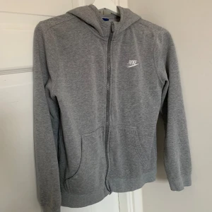 Grå Nike hoodie  - Säljer denna gråa Nike hoodien som jag köpt på second hand! Den är i använt skick men inga synliga defekter 🤍 den är i barnstorlek L men passar xxs-s i vuxenstorlek! Skriv priv vid mer frågor 😊