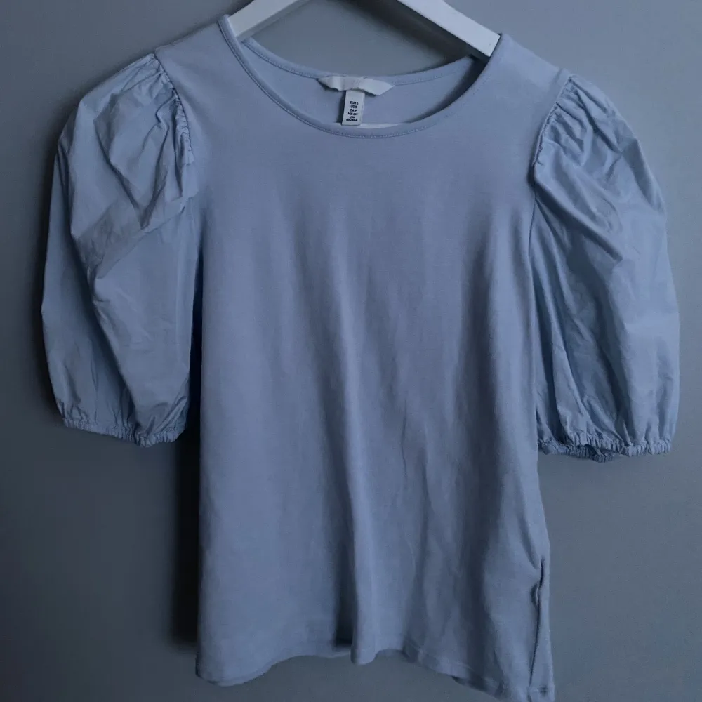 Ljusblå t-shirt med puffiga ärmar. Fint skick och använd fåtal gånger. Köparen stor för frakten. Köp via ”Köp nu” 🩷. T-shirts.