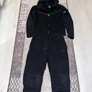 Nike tech fleece svart - Säljer en jätte fin nike tech svart i använt skick, den köptes på Jd för något år sedan men har använs väldigt sparsamt, koftan är i storlek S och byxorna M vid frågor eller funderingar är det bara att höra av er!