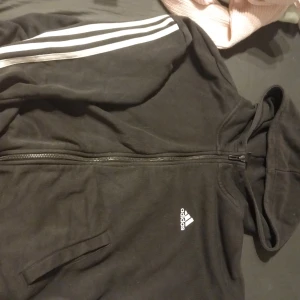 Adidas kofta - Svart basic adidas kofta, väl använd finns lite slitage på muddarna vid armarna. Står att den är L men mer som en M 