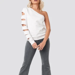 One shoulder tröja AFJ x NAKD - Ljusrosa one shoulder tröja med cutouts. Använd fåtal gånger. Skriv för egna bilder. Från kollektionen AFJ x NAKD. Storlek XS
