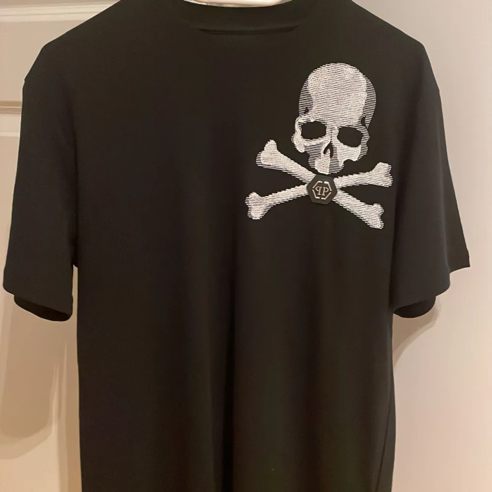 Säljer en svart Philipp Plein T-shirt, helt oanvänd med prislapp på.  Storlek: Small.  Nypris: 5600:- Säljer den för 3000:-inkl fraktkostnad. T-shirts.