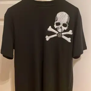 Säljer en svart Philipp Plein T-shirt, helt oanvänd med prislapp på.  Storlek: Small.  Nypris: 5600:- Säljer den för 3000:-inkl fraktkostnad