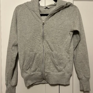 Grå hoodie  - Saknar snörerna och dragkedjan har tappat lite färg men annars i bra skick 