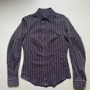 Vivienne westwood skjorta - Luxuös vivienne westwood skjorta i bra kvalle i storlek II (= M). Det är ett vävt tygmaterial cond 7/10.  Den är aningen stor för mig som är en kille som har strlk S, skulle nog passa perfekt på någon snäppet längre! Var inte rädd att ställa frågor!