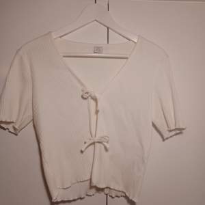 Säljer denna cream vita ribbade t-shirt koftan i nyskick som man kan knyta i mitten✨️Säljer denna för 59 kornor och är köpt för 200🎀