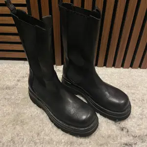 Svarta boots från NA-KD i storlek 40. Köpta för ca 2 år sedan men bara använda en gång, som nya! Nypris 1099kr🖤