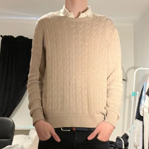 J.lindeberg kabelstickad tröja - Säljer denna feta kabelstickade tröjan från j.lindeberg i färgen beige. Tröjan är i mycket bra skick och inga tecken på användning, passar perfekt med en skjorta under. Storlek M. Hör av er vid frågor eller funderingar! 