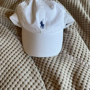 Vit Ralph Lauren keps  - Vit Ralph Lauren keps i 10/10 skick, aldrig använd! Nypris: 600kr. Pris kan diskuteras och om du har någon fråga är det bara att ställa. 😊