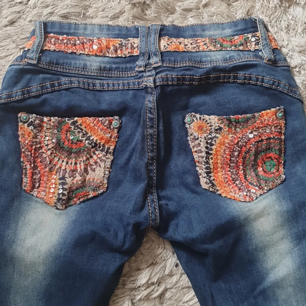 Jeans som är ovanliga  med massa detaljer..massa paljetter både fram och bak snygga knappar låg midjande ..fickor fram bak snygga slitningar storlek 26 passar xs s väldigt fint skick!. Jeans & Byxor.