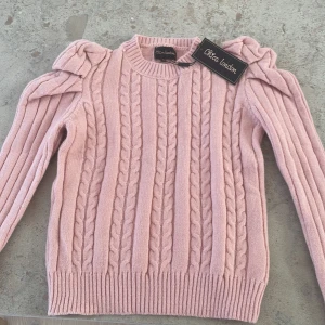 Kabel stickad tröja - ⚠️kontakta på Plick innan köp⚠️Detta är en fin tröja att ha nu till våren eller på hösten. Denna har puffärm. Denna är aldrig använd och lappen sitter kvar. Säljer pg. A att den var för liten. Fick nu i Julas men aldrig orkat ta tag i saken.