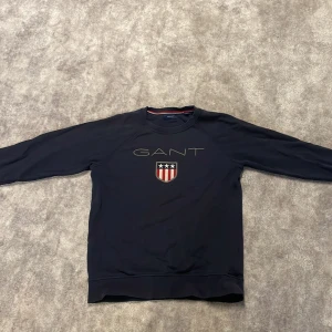 Gant tröja - En riktigt fin gant tröja. Säljer för den blivit för liten för mig. Den har börjat tappa färg vid armbågarna men inget som märks när man väl har på sig den. Storlek 146-152. Färg Marinblå. Priset går att diskutera och om du har mer frågor skriv!