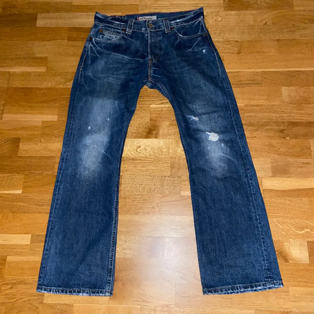 Ett par skit feta Levis 512 bootcut med snygga detaljer. Slitningen på byxorna är del av designen. 24cm i benöppningen, 42cm i midja,  104cm Ytterbenslängd.. Jeans & Byxor.