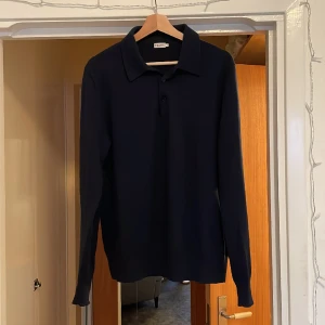 Filippa K långärmad piké  - Mörkblå långärmad piké i merinoull från Filippa K. Nypris är 1900kr