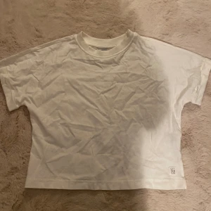 vit cropped t-shirt - cropped t-shirt i super mjukt och skönt material, i barnstorlek 140 men sitter som en magtröja så och den e bred så den är inte för tajt🫶 skriv privat för frågor/bilder på😊