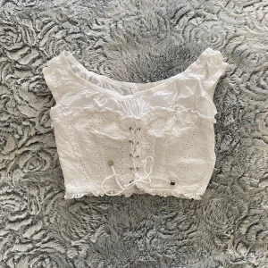 Vit sommartopp S - Otroligt fin vit sommartopp🌸 Snörning fram, dragkedja i vänster sida  Mycket sparsamt använd💕 Skulle säga att den är tajt i ärmarna och passar en XS