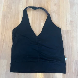 Linne - Ett linne utan axelband, ett sånt man har bakom nacken. Tygbiten bakom nacken är lite missfärgat (se bild 3). Men syns inte mycket när man har på sig den