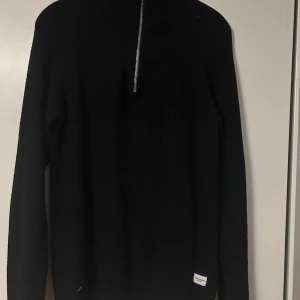 Svart stickad halfzip - Säljer en svart stickad halfzip från Jack & Jones. Väldigt bra skick i storlek M