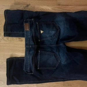 Guess vintage lågmidjade jeans  - Snygga lågmidjade blåa jeans som är utsvängda där nere!