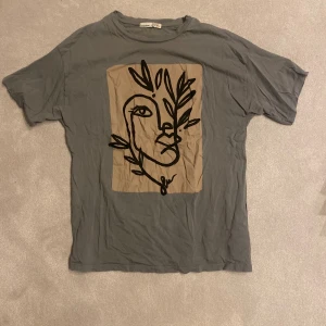 Snygg T-shirt - Snygg grå T-shirt med fint märke på framsidan! Storlek S men passar M också❤️