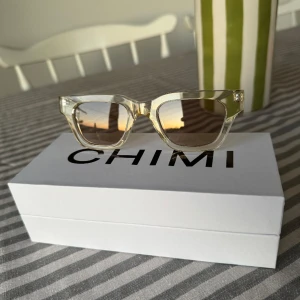 Chimi 11  - Chimi solglasögon  Modell 11 Färg: Light yellow, liknar ecru. I nyskick bara testade hemma.  Kartongen och duken fås med men inte fodralet.