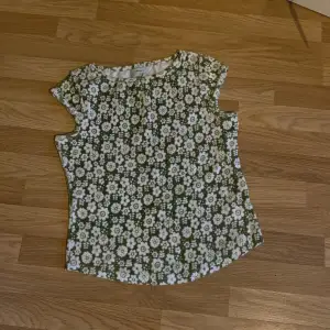 En grön blommig tröja som är väldigt fin på sommarn 