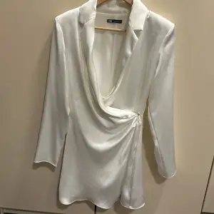 Säljer denna jätte fina korta vita siden kavaj klänning från zara i storlek xs