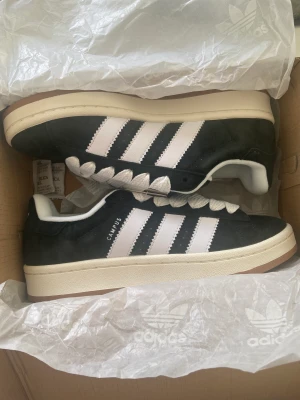 Adidas campus 00s - Säljer nu mina helt oanvända svarta adidas campus skor i väldigt bra skick! Passar väldigt bra och är en av mina favvo skor när det kommer till bekvämlighet. 
