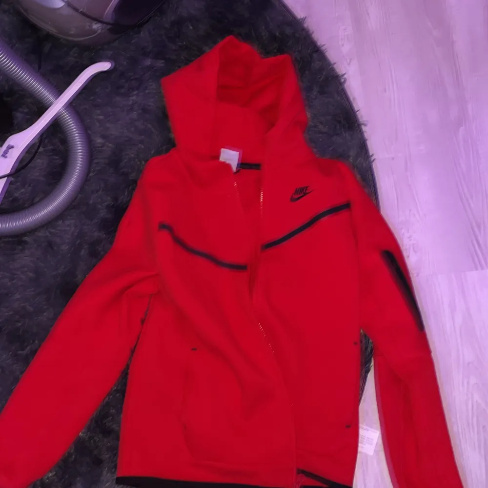 En clean nike tech hoodie i färgen röd . Hupparit & Collegepaidat.