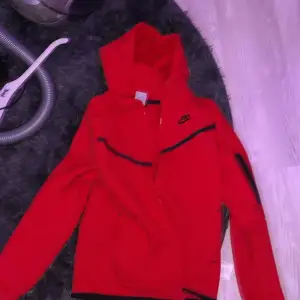 En clean nike tech hoodie i färgen röd 