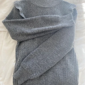 Stickad tröja  - Grå stickad tröja med puffiga armar och volanger 