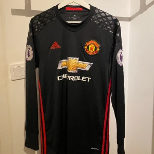 Manchester United svart tröja - Säljer en lång svartärmad tröja adidas som är köpt i old trafford 2016. Den är 100% äkta med tagg (kontakta för bevis). Den är i absolut nyskick då jag bara haft på mig 1-2 gånger bara, inga hål, inga bitar som ramlat av. Skriv för mer info 🤙🏼