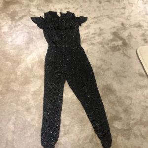 Svartglittrig byxdress - Jättefin svart och silverglittrande byxdress från Kappahl, perfekt till nyår