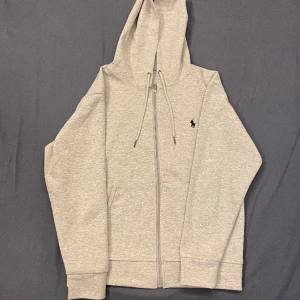 Polo Ralph Lauren Hoodie  - Oanvänd skick 10/10. Dålig belysning på bilderna men den är grå och inte vit. Kommer tyvärr utan tag så kan tänkas på prisändring. Hör av er om minsta funderingar.