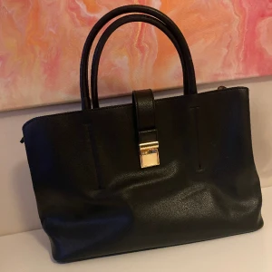 Handväska  - Handväska från H&M med två stora fack och ett lite mittemellan. Fint skick, sparsamt använd 