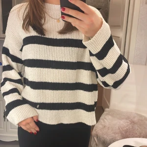 Stickad tröja - Vit stickad tröja med svarta ränder från Pull&Bear, rätt tunn i materialet men väldigt skön!! Kanppt änvänd så tröjan är i fint skick!