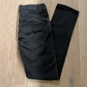 Nudie Jeans - Ett par feta svarta Nudie Jeans! Jeansen är i ett väldigt bra skick, finns inga deffekter. Jeansen är i storlek 30/32 och i modellen Grim Tim (slimfit). Nypris: 1600. Skriv om ni har några frågor eller om ni vill ha fler bilder.