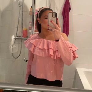 Rosa blus  - Jättesöt rosa One shoulder blus med volanger som aldrig kommit till användning. Vet inte exakt vilket märke det är.. 