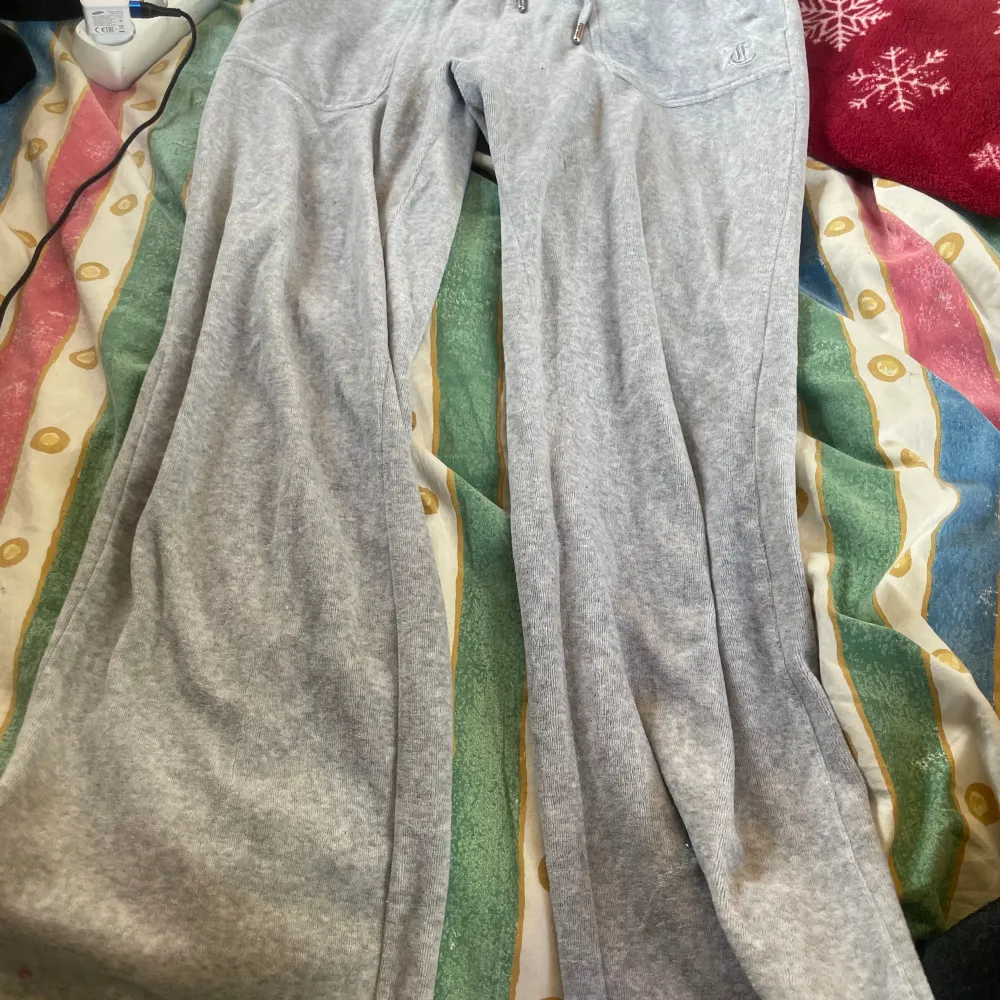 Ett par grå juciy byxor som är för små för mig och dom har en brun fläck som man kan se på bilden går bort i tvätten kan försöka att tvätta dom innan jag skickar dom till den som vill ha dom . Jeans & Byxor.