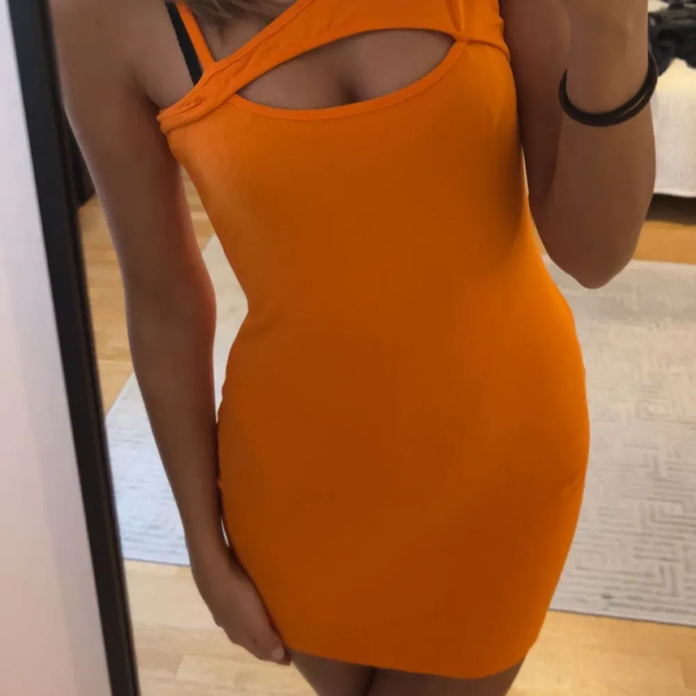 Orange klänning med detaljer. Klänningar.