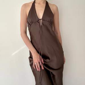 Helt ny lång mörkbrun långklänning med djup rygg i ett satinliknande tyg från Zara i storlek XS. Perfekt balklänning eller bröllopsgästklänning! Sista två bilderna är lånade.