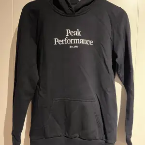 En svart hoodie från peakpreformance använd endast två gånger då jag fick den när den var för liten. Storlek är 170 🐧