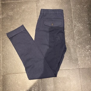 Kostymbyxor - Super fina och stilrena kostymbyxor från dressman i storlek 29-30. Blev tyvärr för små ganska snabbt så knappt använda! Blåa med fickor bak. Hör av er vid frågor!