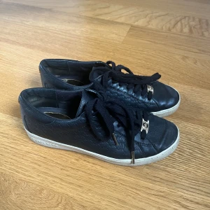 Svarta Michael Kors Skor - Köpte dem här skorna för ett tag sedan, använt dem relativt mycket men inga stora skador. Är lite smutsiga men är lätta att göra rent. Nypris 1700 kr. Köparen står för prakten och jag står inte för postens fel 