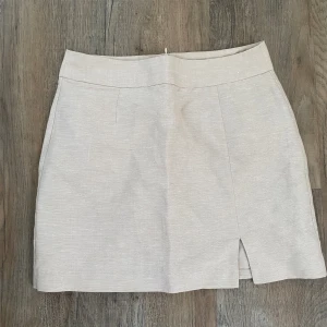 Linnen kort kjol  - Linnen kjol från Gina med en liten slits. Nyskick.