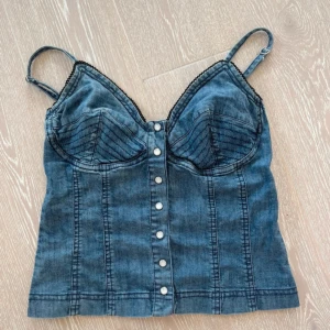 Jeanstopp - Jeanstopp med knäppning fram. Stretchigt material.