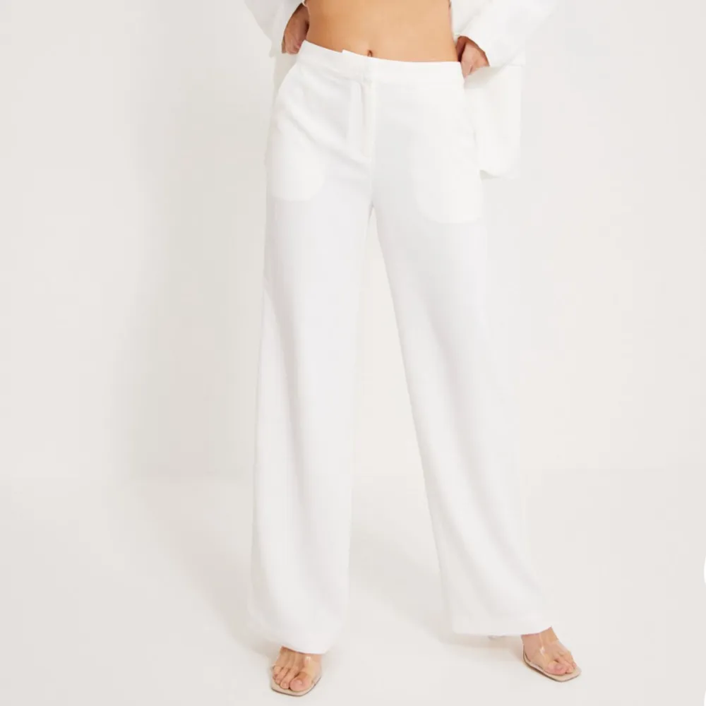 Fina vita kostymbyxor från Nelly, aldrig använt. Köptes för 499kr och säljer för 299kr💕storlek  32 men passar 34/36 då de är långa . Jeans & Byxor.