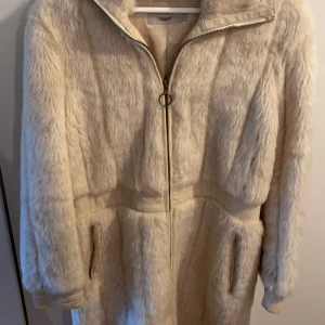 Vinterjacka, päls - Jackan är köpt år 2000 och är en elegant vinterjacka för damer. Kostade cirka 6000kr när den köptes in. Använd ca 5 gånger, inga fläckar eller förstörelse överhuvudtaget. Den känns som helt ny. 